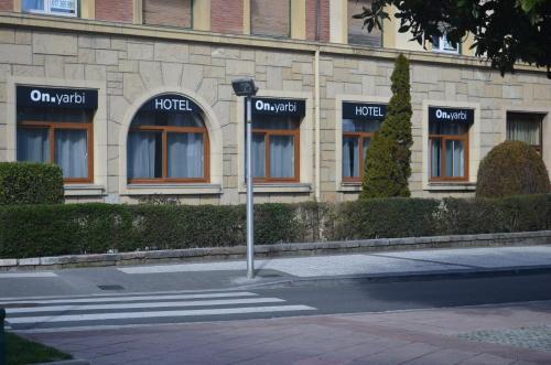 a building with windows and a street sign in front at Hotel Onyarbi in Hondarribia