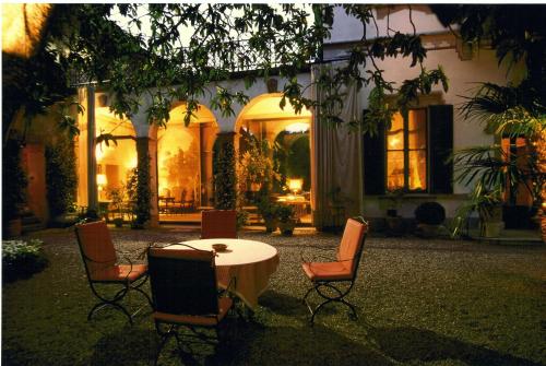 a table and chairs in a courtyard at night at Hotel Locanda Dei Mai Intees in Azzate