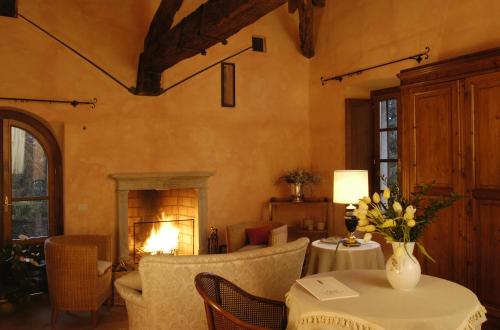 a living room with a fireplace and a table and chairs at Hotel Locanda Dei Mai Intees in Azzate
