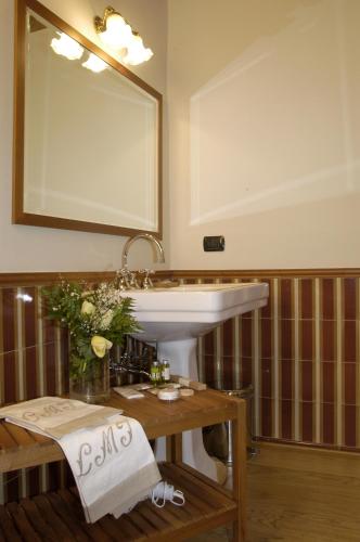 a bathroom with a sink and a table and a mirror at Hotel Locanda Dei Mai Intees in Azzate