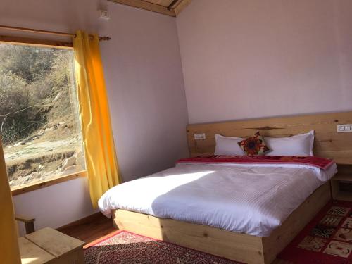 a small bedroom with a bed and a window at Mountain Rover Auli Resort in Joshīmath