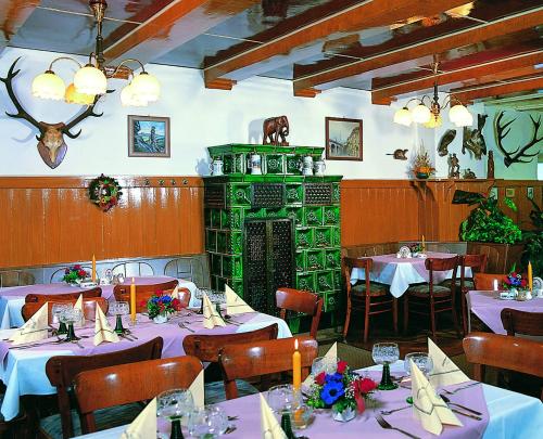 ケーニッヒスシュタイン・アン・デ・エルベにあるPension Schrägersの白いテーブルクロスのテーブルと椅子が備わるレストラン