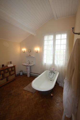 une salle de bain avec une baignoire et une fenêtre dans l'établissement The Retreat @ Le Grand Bois, à Miramont-de-Guyenne