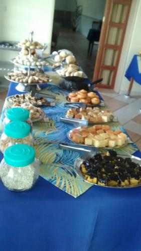 a long blue table with plates of food on it at Casa da Ponte Hotel in Goiás