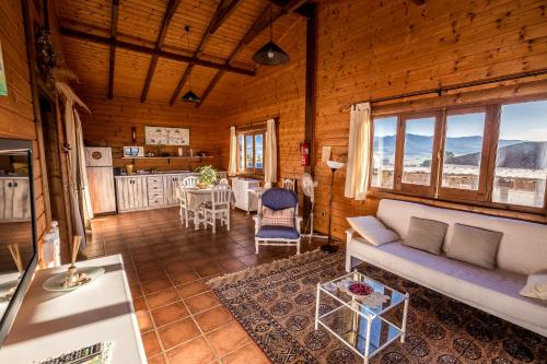 ein Wohnzimmer mit einem Sofa und einem Tisch sowie eine Küche in der Unterkunft Rural Tarifa Beach Las Cabañas in Tarifa