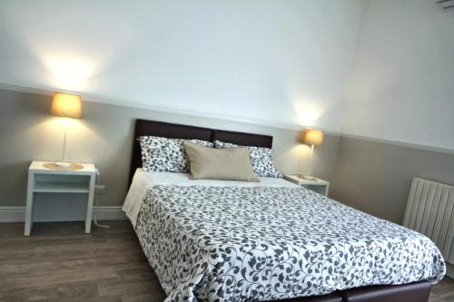 a bedroom with a bed with two tables and two lamps at Principe in Bari