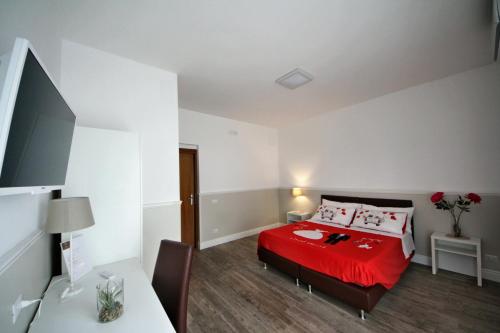 a bedroom with a red bed and a desk at Principe in Bari