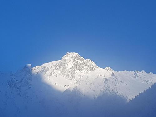 a mountain covered in snow on a clear day at Auberge du Manoir in Chamonix-Mont-Blanc
