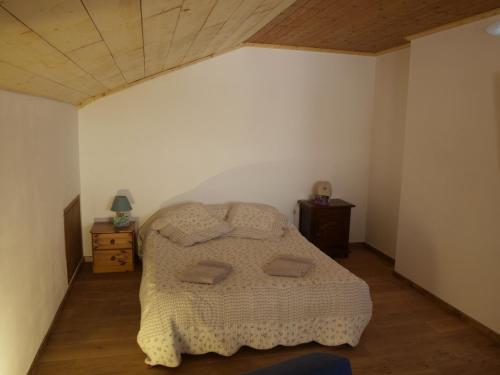 een slaapkamer met een bed en een houten plafond bij Abeille Saint Michel in Marthod