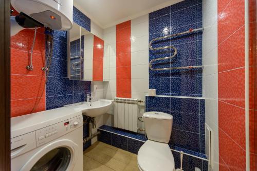 a bathroom with a toilet and a sink and a washing machine at Iordanska Street Apartments in Kyiv