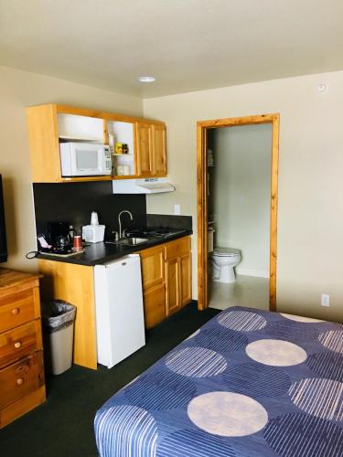 a hotel room with a bed and a kitchen at Boulder Creek Inn in Donnelly