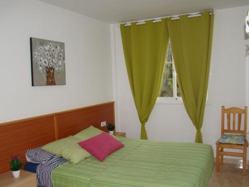 Un dormitorio con una cama verde y una ventana en Apartamento Cap de Salou, en Salou
