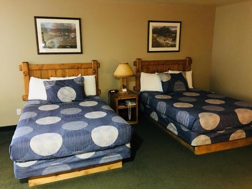 a bedroom with two beds and a lamp on a table at Boulder Creek Inn in Donnelly