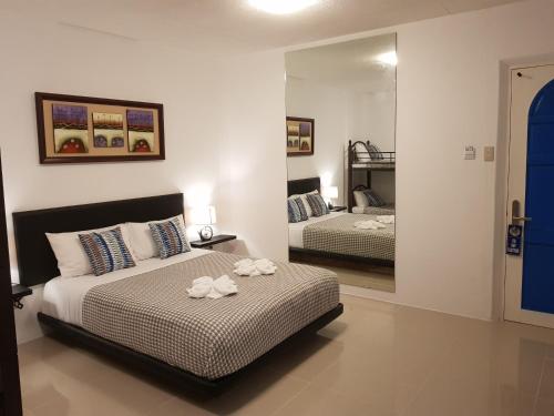 a bedroom with two beds and a mirror at D´Gecko Hotel in Moalboal