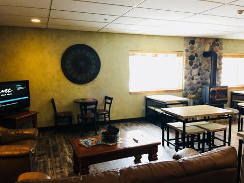 a living room with a couch and tables and a screen at Boulder Creek Inn in Donnelly