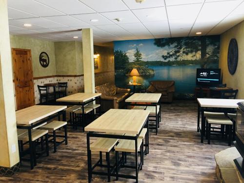 唐纳利Boulder Creek Inn的一间摆着桌椅、墙上挂着一幅画的餐厅