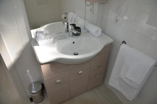 a bathroom with a white sink and a shower at Crystal B&B in Dormelletto