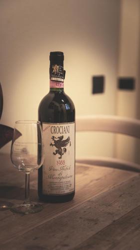 a bottle of wine next to a glass on a table at Porta delle Farine in Montepulciano