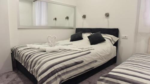 - une chambre avec un lit et un grand miroir dans l'établissement Apartment Centar, à Užice