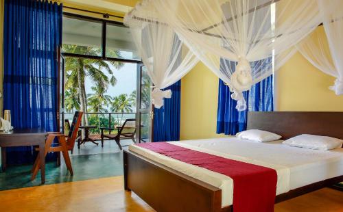 a bedroom with a bed with curtains and a desk at Sath Villa Naadi Ayurveda Resort in Moragalla