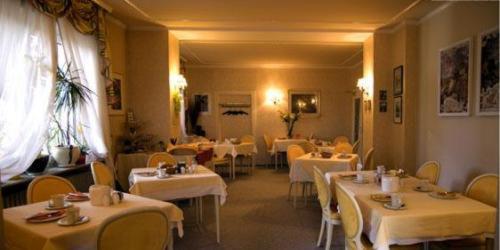 a restaurant with white tables and yellow chairs and white tables at Hotel Kurpfalz in Speyer