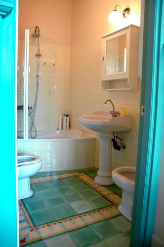 a bathroom with a sink and a tub and a toilet at Hotel Villa Itsaso in Lekeitio
