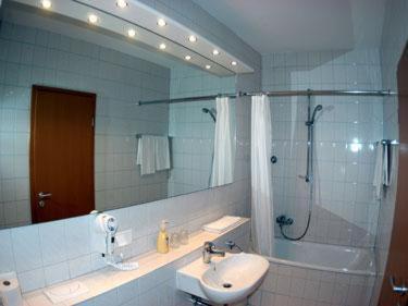 a bathroom with a sink and a shower and a mirror at Hotel Kurpfalz in Speyer