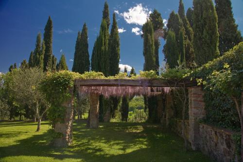 an archway in a garden with trees and bushes at Villa Barberino in Meleto