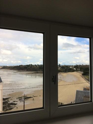 a view of a beach from a window at Katy's Home Dinard in Dinard