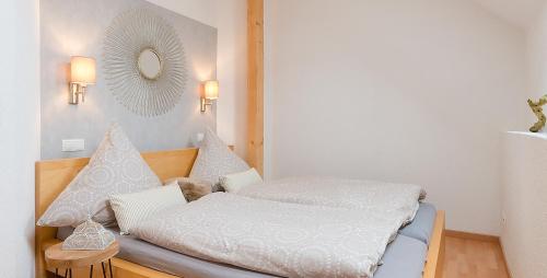 MünstermaifeldにあるAm Quittenbaumのベッドルーム1室(白いシーツと鏡付きのベッド1台付)