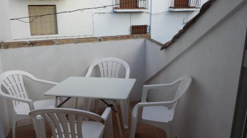 una mesa y sillas junto a una pared con ventanas en Alojamiento rural La Casilla en Cazorla