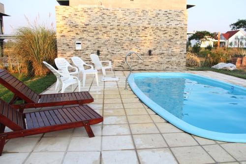 a group of chairs and a swimming pool at Complejo Amarelo in Chajarí