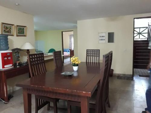 a kitchen and dining room with a wooden table and chairs at Lippo Carita Beach Utara Condo Noah in Carita