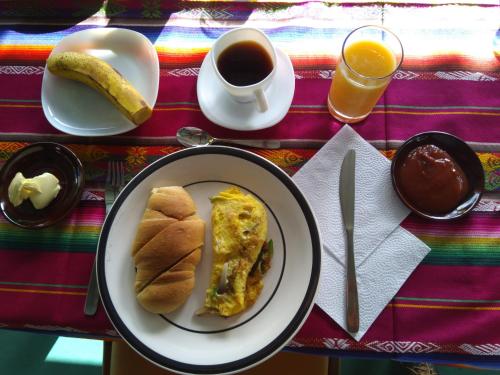 a table with a plate of breakfast food and coffee at Suymar Ecolodge Galapagos in Puerto Ayora