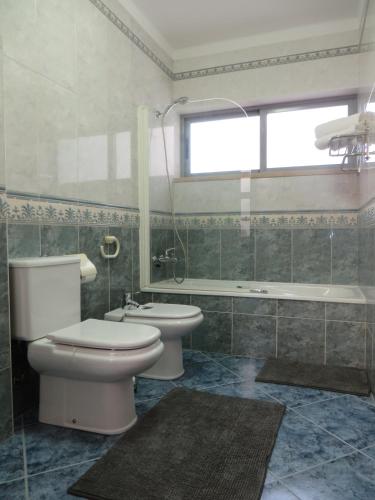 a bathroom with a toilet and a sink and a tub at Casa de Férias Sesimbra in Sesimbra