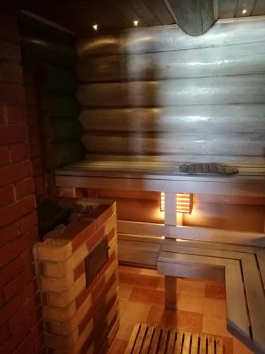 a wooden bench in a room with a brick wall at Rähni Guesthouse Lake Peipsi in Vilusi