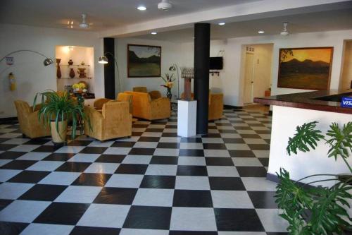 a lobby with a checkered floor and furniture at Hotel Iguana Azul in Honda
