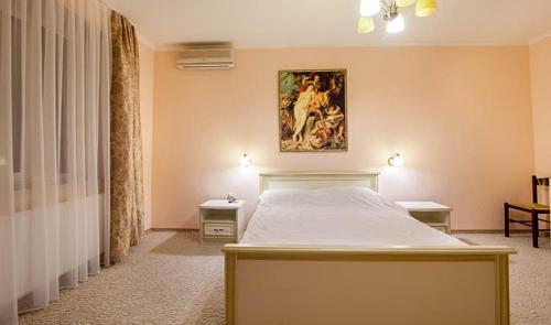 a bedroom with a bed and a painting on the wall at Veles Hotel in Dnipro