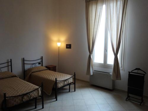 ボローニャにあるDue Agosto Apartmentsのベッド2台と窓が備わる客室です。