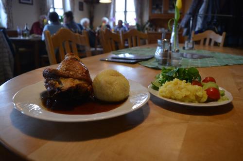 two plates of food on a wooden table with food at Hofstub´n in Eschlkam