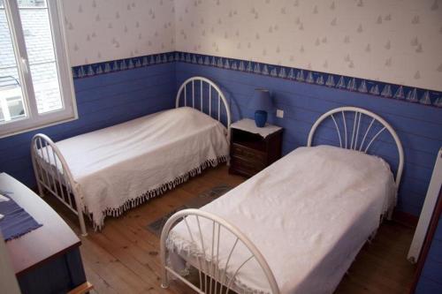 2 camas en una habitación con paredes azules en Gite les Flots Bleus, en Jullouville-les-Pins