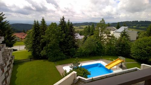 una piscina en un patio con un tobogán en Alpenblick, en Sankt Englmar
