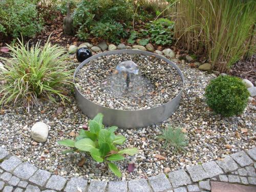 a garden with a fountain in the middle of a yard at Ferienwohnung Himmelsbach in Schuttertal