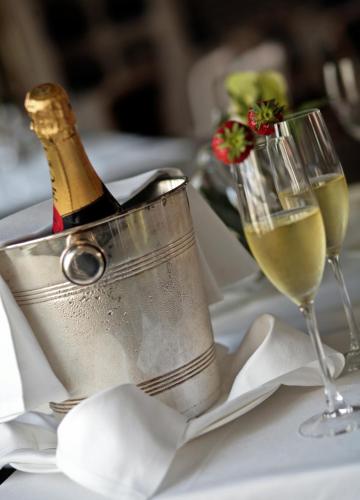 a bottle of champagne in a bucket on a table with two glasses at Grand Visconti Palace in Milan