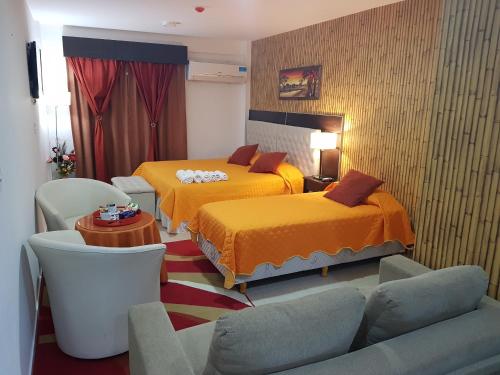 a hotel room with two beds and a couch at Angeluz Departamentos Temporarios Solar Obligado in Resistencia