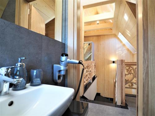 a bathroom with a white sink and wooden walls at VIP APARTAMENTY VILLA GÓRSKIE KLIMATY in Zakopane