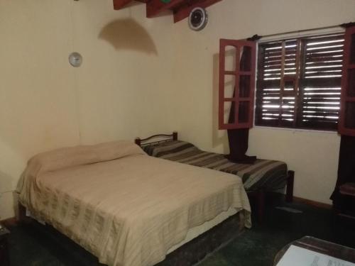a bedroom with two beds and a window at Parador La Rosita in San Agustín de Valle Fértil