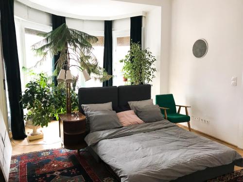 a bedroom with a bed in a room with plants at Spacious Bauhaus icon flat with fitness room in Central Buda, close to the river and Margaret island in Budapest