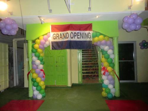 a grand opening sign in front of a door with balloons at PG Quality Inn in Georgetown