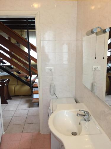 un baño con lavabo y espejo en Villino Colussi, en Lignano Sabbiadoro